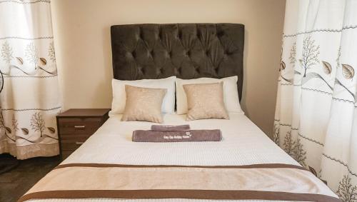 a bedroom with a bed with a large headboard at Grey Oak Holiday House in Bulawayo