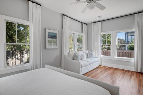 une chambre avec un lit, un canapé et des fenêtres dans l'établissement The Cottage, à Santa Rosa Beach