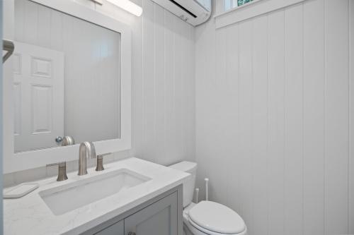 une salle de bain avec un lavabo, des toilettes et un miroir dans l'établissement The Cottage, à Santa Rosa Beach