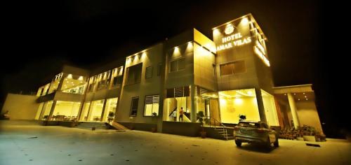 un bâtiment avec une voiture devant lui la nuit dans l'établissement Hotel Amar Vilas, à Bharatpur