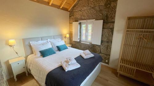 1 dormitorio con 1 cama con toallas en Quinta da Cumieira Nova, en Seia