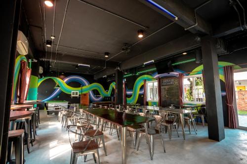 um restaurante com mesas e cadeiras numa sala com paredes coloridas em Mad Monkey Chiang Mai em Chiang Mai