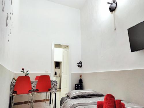 una camera con due sedie rosse e un letto di Odeon Homes - Centro Storico a Catania