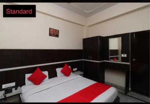 a bedroom with a large bed with red pillows at hotel dreamland in Haridwār
