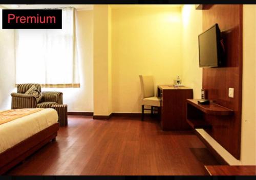 una camera d'albergo con letto e TV di hotel dreamland a Haridwār
