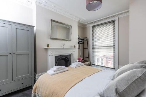 um quarto branco com uma cama com lareira em Stunning 2 Bed in the Centre of Cheltenham! em Cheltenham