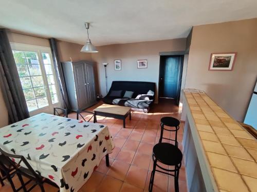 - un salon avec une table, des chaises et un canapé dans l'établissement appartement avec vue panoramique, à Combaillaux