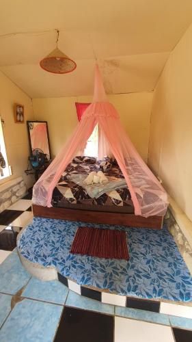 a bed with a canopy in a room at Sumatra Cheeky Monkeys in Bukit Lawang