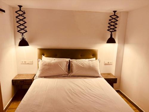 a bedroom with a bed with two lights above it at Casa Olivia, Luxurious Village House with Sauna and Jacuzzi in Finestrat