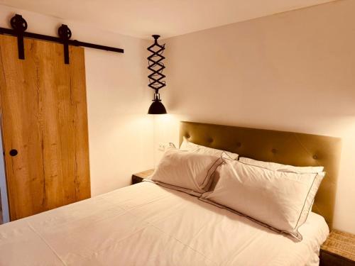 a bedroom with a white bed with a wooden headboard at Casa Olivia, Luxurious Village House with Sauna and Jacuzzi in Finestrat