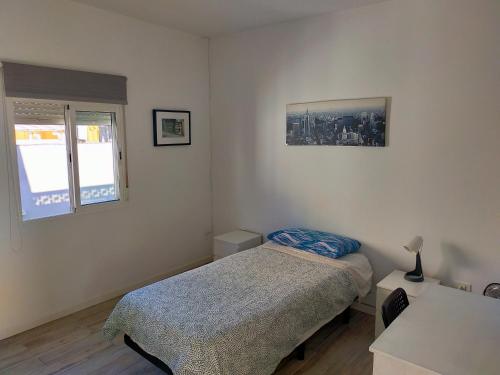 a small bedroom with a bed and a window at Urban room in La Laguna
