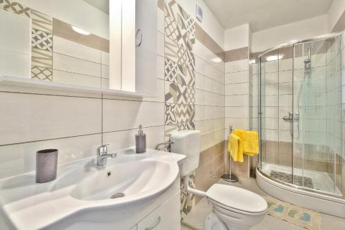 a white bathroom with a sink and a toilet at Exklusive 4-Sterne-Villa Mare - WLAN - Pool - Grill in Plovanija