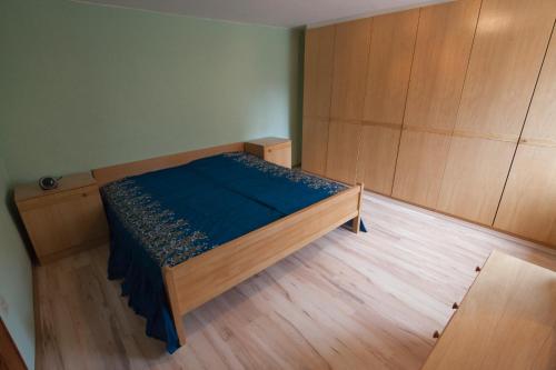 a small bedroom with a bed with a blue sheets at Zeiler Peter und Luisie in Waging am See