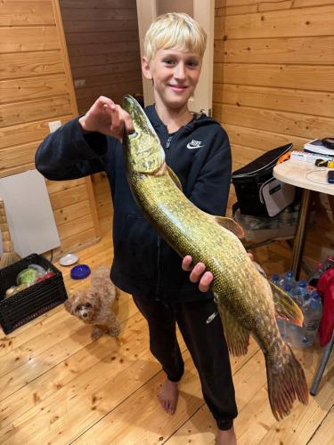 a boy holding a large fish in his hand at Casa de Greta in Svityazʼ