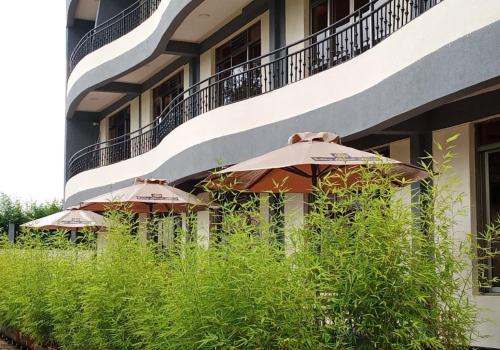 three umbrellas sitting on the side of a building at Sabby Grand Hotel in Ithumba