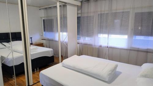 a room with two beds and a mirror at Room in shared apartment in Friedrichshafen