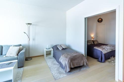 a bedroom with a mirror and a bed and a couch at Regatta Seaside Suite in Hanko in Hanko