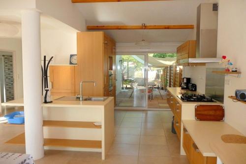 une cuisine avec un évier et une cuisinière dans l'établissement VILLA SECANTO Belle Villa Individuelle avec grand jardin Rochelongue Cap d'Agde, au Cap d'Agde
