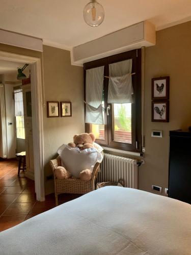 a teddy bear sitting in a chair in a bedroom at Il Riccio appartamento in Cernobbio
