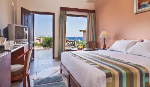 une chambre d'hôtel avec un lit et une télévision dans l'établissement Xperience Hill-Top Beach Resort, à Charm el-Cheikh
