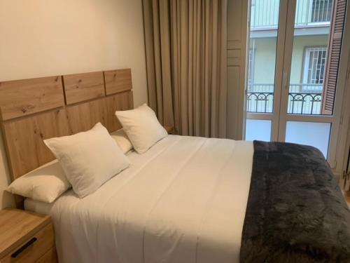 um quarto com uma grande cama branca e uma janela em Rosa 2 Bedrooms in City Center em Málaga