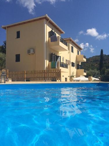 a villa with a swimming pool in front of a house at Sunset View Studios in Exanthia