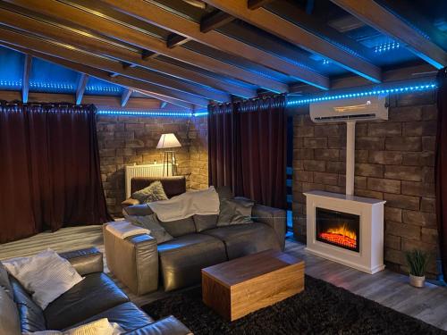 a living room with a couch and a fireplace at Natur’Lovers - Chalet d’exception - Jacuzzi et hammam en pleine nature in Grendelbruch