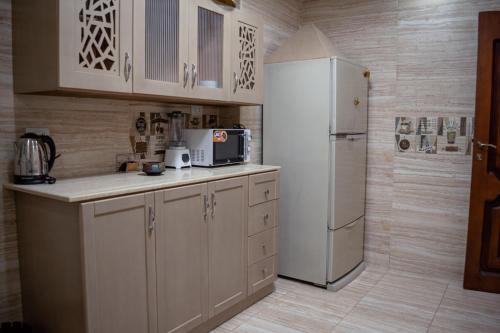 a kitchen with a refrigerator and a microwave at شقه فندقيه مواجهه للأهرامات. Hotel Apartment in Cairo