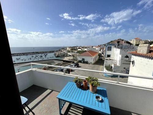 a blue table on a balcony with a view of the ocean at Zen House in Sines