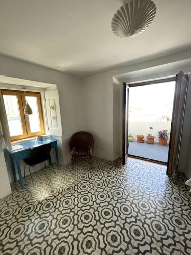 a room with a door open to a room with a piano at Zen House in Sines