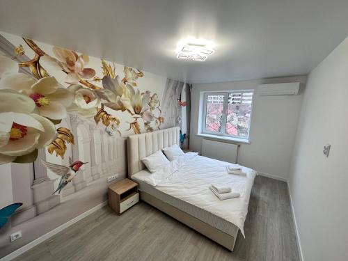 - une chambre avec un lit orné d'une fresque murale représentant des fleurs dans l'établissement ApartPlus Truskavets - Затишні апартаменти, à Trouskavets