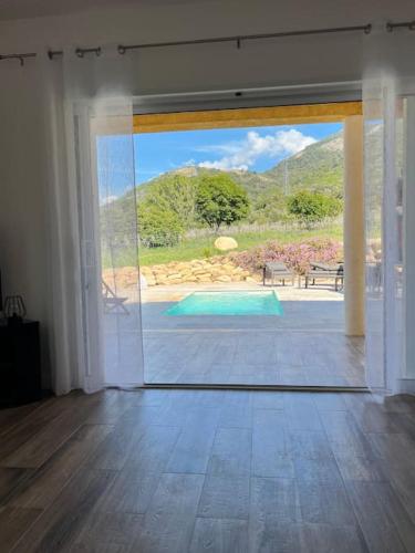 a room with a door open to a swimming pool at Très belle villa au calme avec piscine à Sagone in Sagone