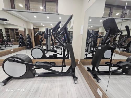 a gym with several treadmills and a mirror at Hotel Sharq in Dushanbe