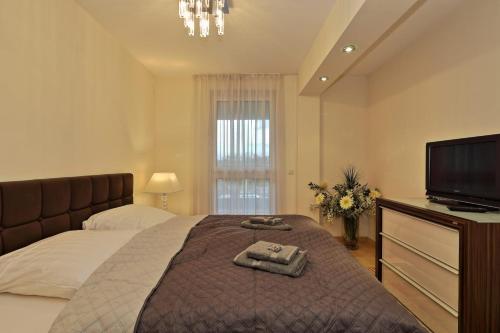 um quarto com uma cama, uma televisão e toalhas em Penthouse Mülheim- Ruhr - Zentral - Edel - Luxus pur em Mülheim an der Ruhr