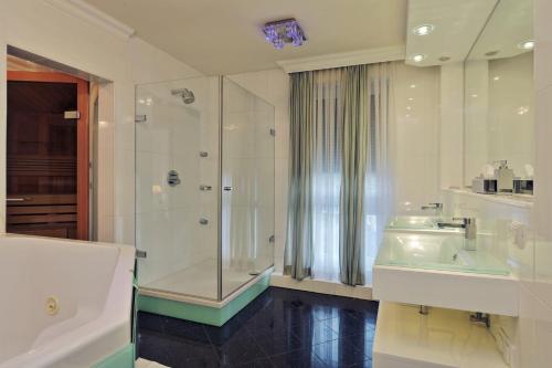 La salle de bains est pourvue d'une douche, d'un lavabo et d'une baignoire. dans l'établissement Penthouse Mülheim- Ruhr - Zentral - Edel - Luxus pur, à Mülheim