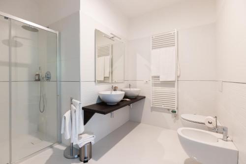 uma casa de banho branca com 2 lavatórios e um chuveiro em Salsomaggiore Golf Guest House em Salsomaggiore Terme