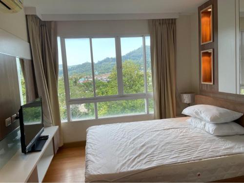 - une chambre avec un lit et une grande fenêtre dans l'établissement Risa Plus2, à Kathu