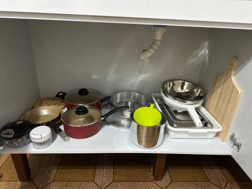 a shelf in a kitchen with pots and pans at Casa próxima ao Centro in Caraguatatuba