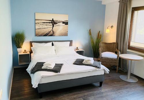 een slaapkamer met een groot bed en handdoeken bij Hotel dat Norden in Horumersiel