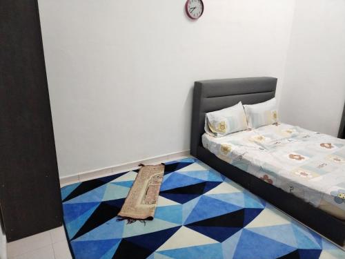 1 dormitorio con 1 cama y suelo azul y blanco en AqilD Homestay, en Jasin