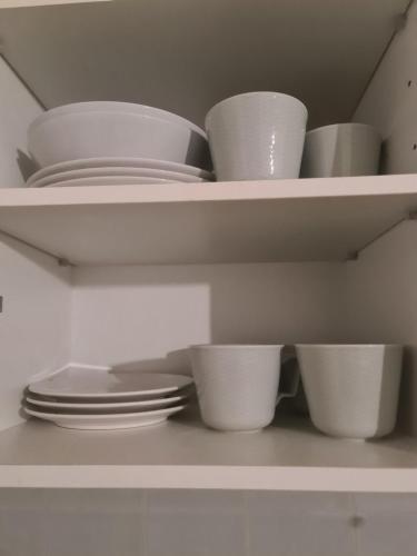 a white shelf with white bowls and plates on it at Studio Gotic in Barcelona
