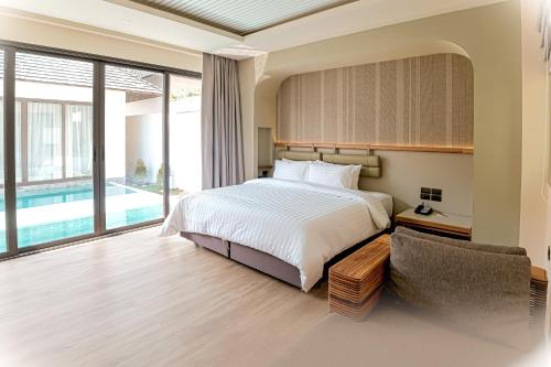 a bedroom with a bed and a pool at Baan Haad Ngam Boutique Resort in Chaweng