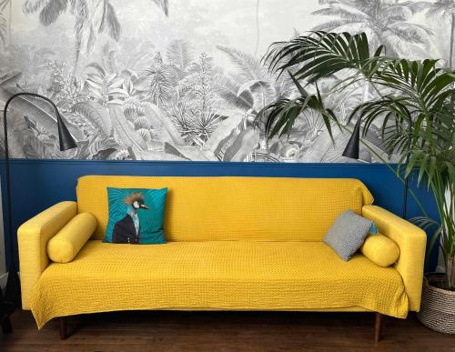 a yellow couch in a room with plants at Eden Blue charmant appartement proche centre avec Garage Gratuit in Nantes