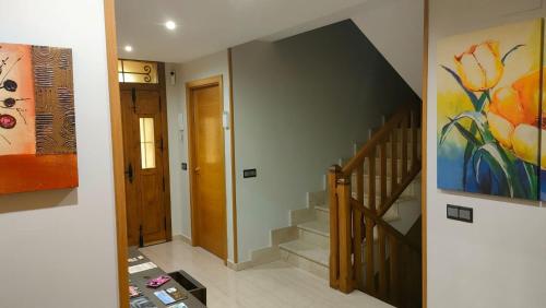 un pasillo con una escalera y una pintura en la pared en Casa Entre Rosales en Candeleda
