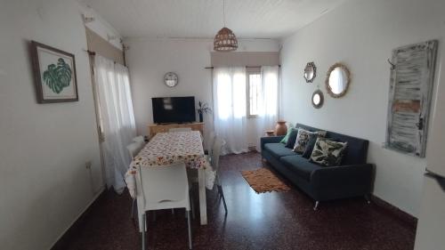 uma sala de estar com um sofá e uma mesa em Casa y monoambiente para 8 patio y 3 garaje - Tangará em Posadas