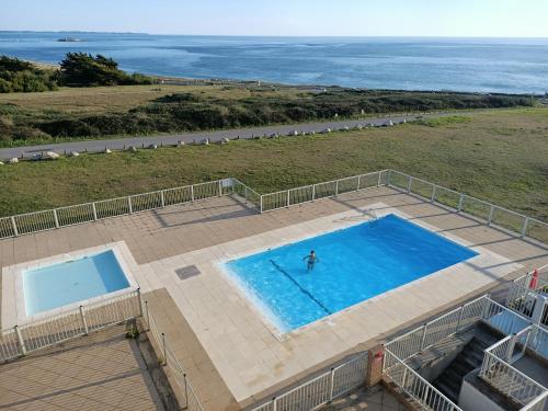 una vista sul tetto di una piscina con una persona di Vacances face à la mer! a Guidel