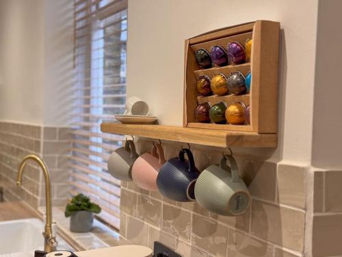 a kitchen with a shelf with cups on the wall at Beautiful, Relaxing Home in Central Saltaire in Saltaire