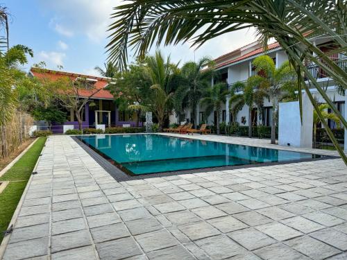 uma piscina em frente a uma casa em The Reef Resort em Nilaveli