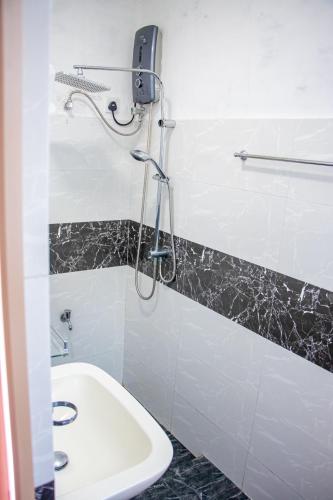a bathroom with a shower and a toilet and a sink at DiNi Galle in Galle