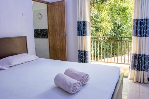 a bed with two towels sitting on top of it at DiNi Galle in Galle